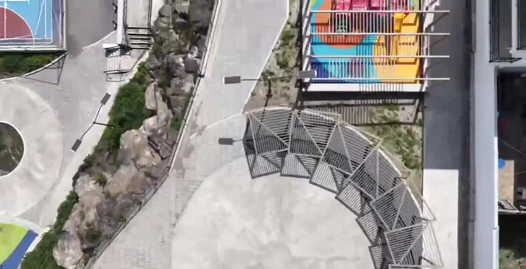 Vista aérea a plomo de un parque deportivo con cancha de colores, skatepark y andadores