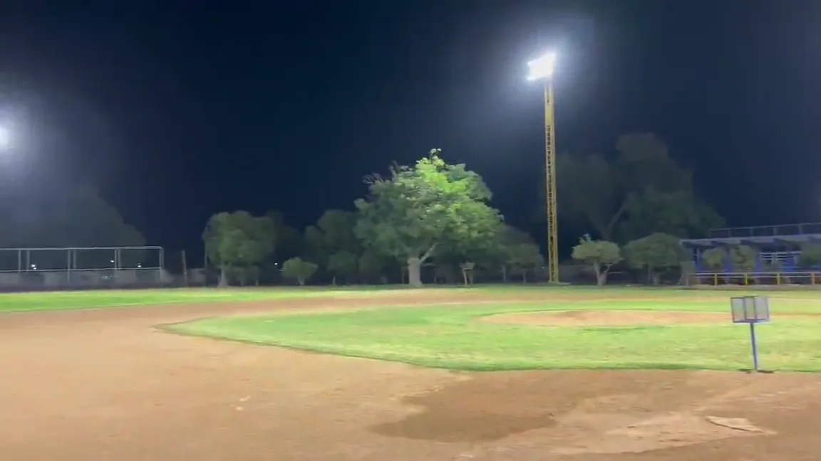 Campo de béisbol iluminado de noche con torres de reflectores LED encendidas
